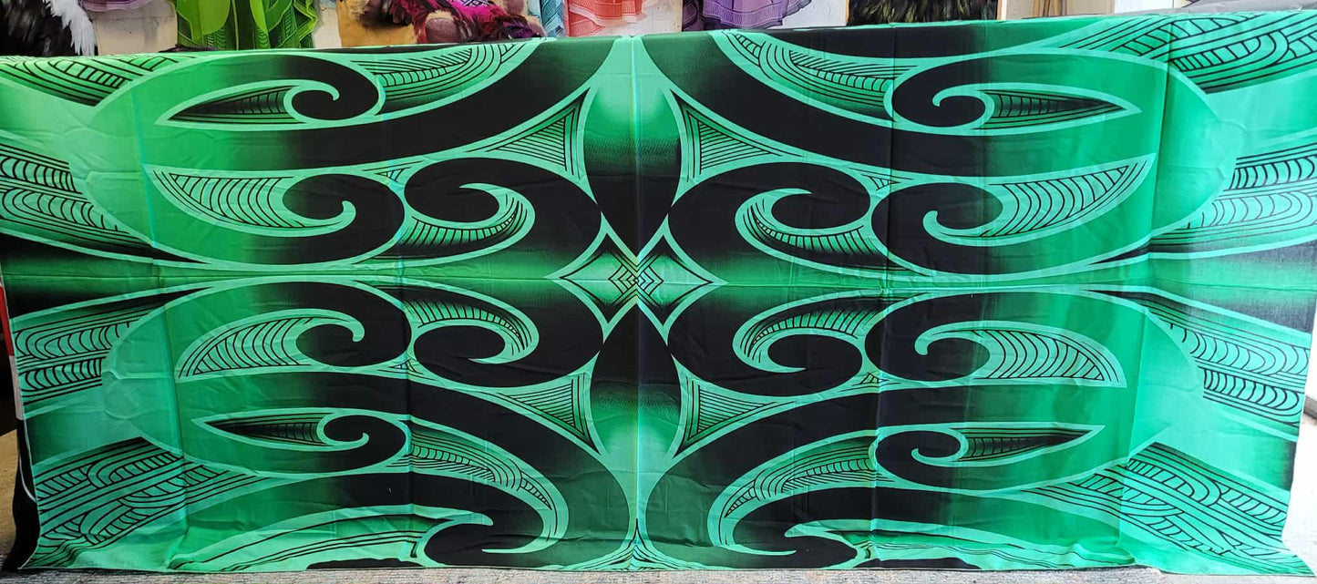 Green and black decorative patterned tablecloth with intricate designs.